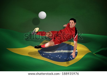 Football player in red kicking against white leather football with shadow