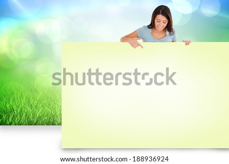 Composite image of pretty brunette showing yellow card