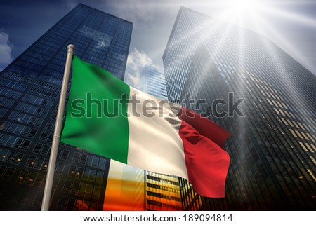 Italy national flag against low angle view of skyscrapers at sunset