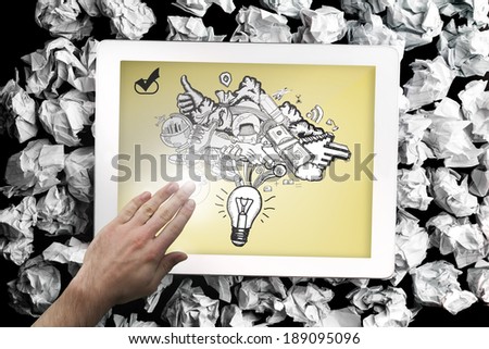 Composite image of hand touching tablet showing ideas doodle
