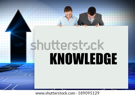 Business partners showing card saying knowledge against digital background