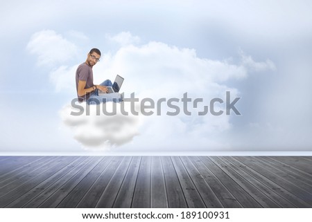 Man wearing glasses sitting on cloud using laptop and looking at camera against clouds in a room