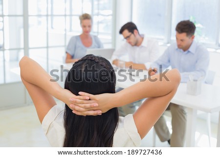 Casual businesswoman leaning back during a meeting in the office