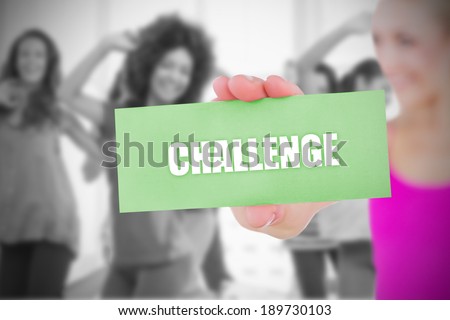 Fit blonde holding card saying challenge against dance class in gym