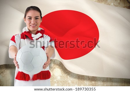 Composite image of football fan in white wearing scarf holding ball against japan flag