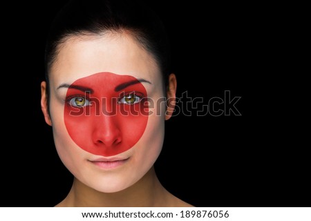 Composite image of japan football fan in face paint against black