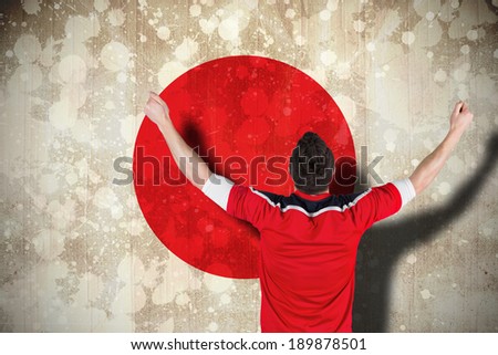 Composite image of excited football fan cheering against japan flag