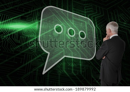 Composite image of speech bubble and businessman looking against green and black circuit board