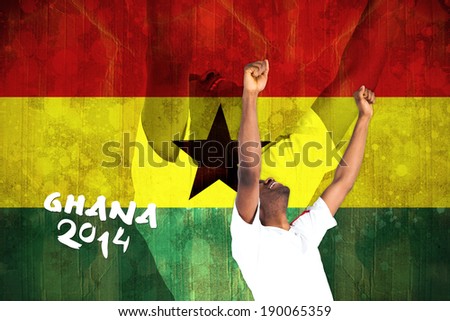 Excited handsome football fan cheering against ghana flag in grunge effect