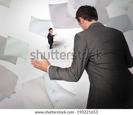 Businessman posing with hands out with tiny businessman against grey vignette