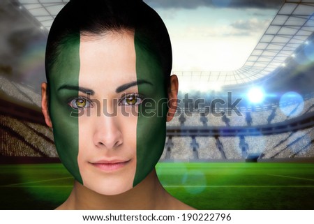Composite image of beautiful nigeria fan in face paint against vast football stadium with fans in white