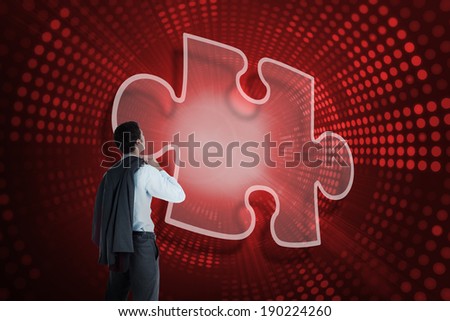 Composite image of jigsaw piece and businessman looking against red pixel spiral