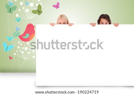 Composite image of attractive couple showing card