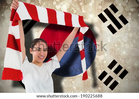Football fan waving red and white scarf against south korea flag