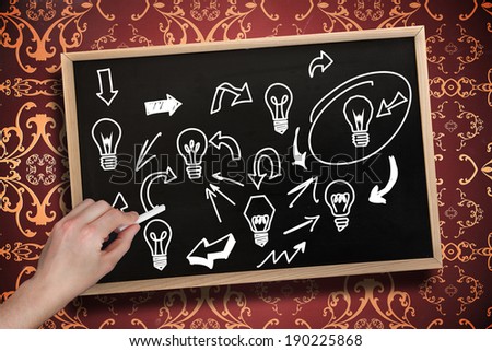 Composite image of hand drawing light bulbs with chalk on chalkboard with wooden frame