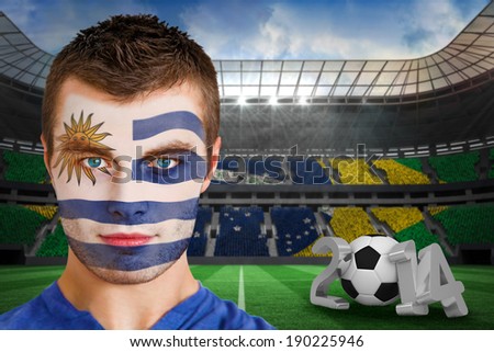 Composite image of serious young uruguay fan with facepaint against large football stadium