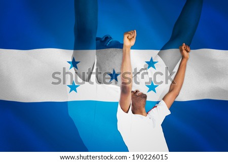 Excited handsome football fan cheering against digitally generated honduras national flag