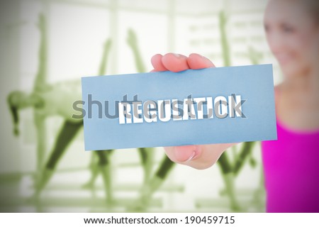 Fit blonde holding card saying regulation against fitness class in gym