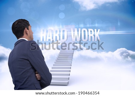 The word hard work and unsmiling asian businessman with arms crossed against shut door at top of stairs in the sky