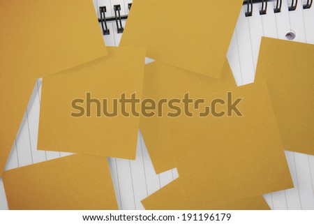 Yellow paper strewn over notepad paper