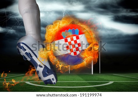 Football player kicking flaming croatia flag ball against football pitch under stormy sky