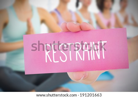 Woman holding pink card saying restraint against fitness class in gym
