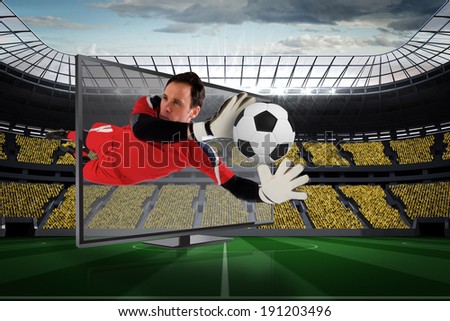 Composite image of fit goal keeper saving goal through tv against vast football stadium with fans in yellow