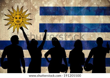 Silhouettes of football supporters against uruguay flag in grunge effect