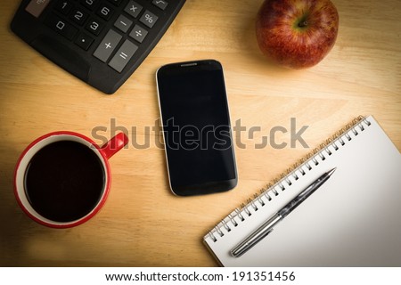 Overhead of smartphone with pen on a desk