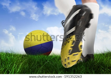Composite image of football boot kicking colombia ball against field of grass under blue sky