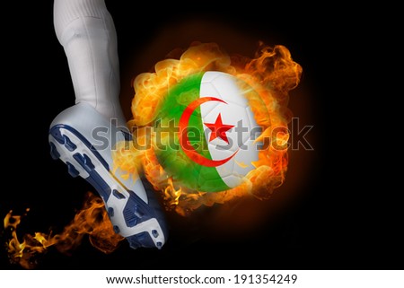 Football player kicking flaming algeria ball against black