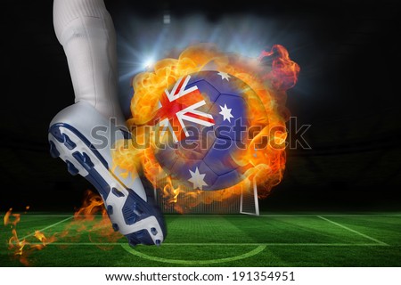 Football player kicking flaming australia flag ball against football pitch and goal under spotlights