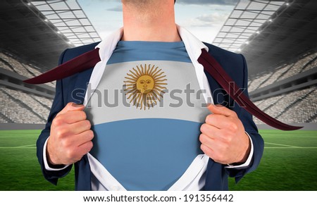 Businessman opening shirt to reveal argentina flag against vast football stadium with fans in white