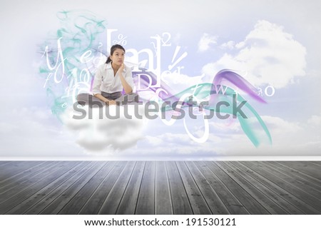 Businesswoman sitting cross legged thinking against clouds in a room