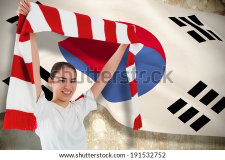 Football fan waving red and white scarf against korea republic flag