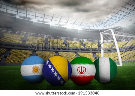 Composite image of footballs in group f colours for world cup against large football stadium with lights