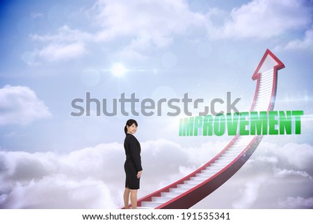 The word improvement and smiling businesswoman against red stairs arrow pointing up against sky