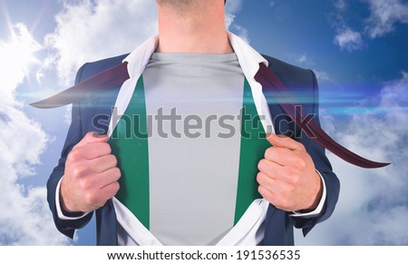 Businessman opening shirt to reveal nigeria flag against bright blue sky with clouds