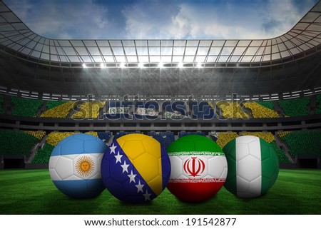 Composite image of footballs in group f colours for world cup against large football stadium with brasilian fans