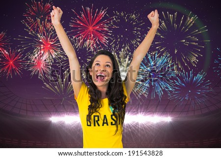 Excited football fan in brasil tshirt against fireworks exploding over football stadium