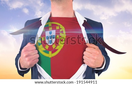 Businessman opening shirt to reveal portugal flag against beautiful orange and blue sky