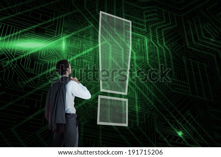 Composite image of exclamation mark and businessman looking against green and black circuit board