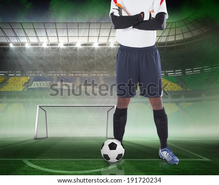 Composite image of goalkeeper standing with ball against vast football stadium for world cup