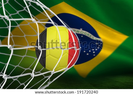 Football in germany colours at back of net against brazilian flag waving