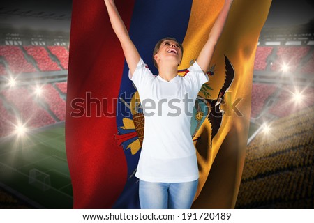 Pretty football fan in white cheering holding ecuador flag against vast football stadium with fans in yellow and red
