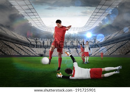 Football player in red kicking against large football stadium with lights