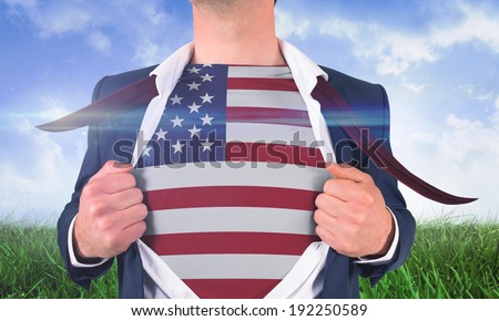 Businessman opening shirt to reveal usa flag against field of grass under blue sky