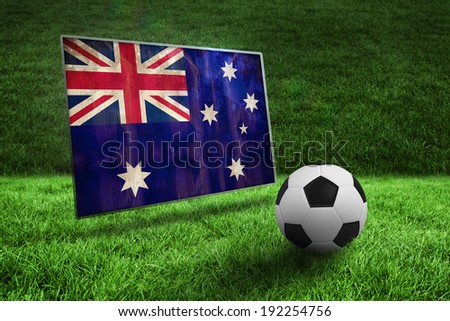 Black and white football on grass against australia flag in grunge effect