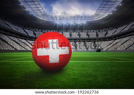 Football in swiss colours in vast football stadium with fans in white