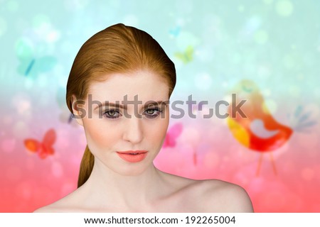 Beautiful redhead looking at camera against girly bird and butterfly design